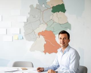 Hilal Matter in einem Workshopraum mit einer Karte des DACH-Raums